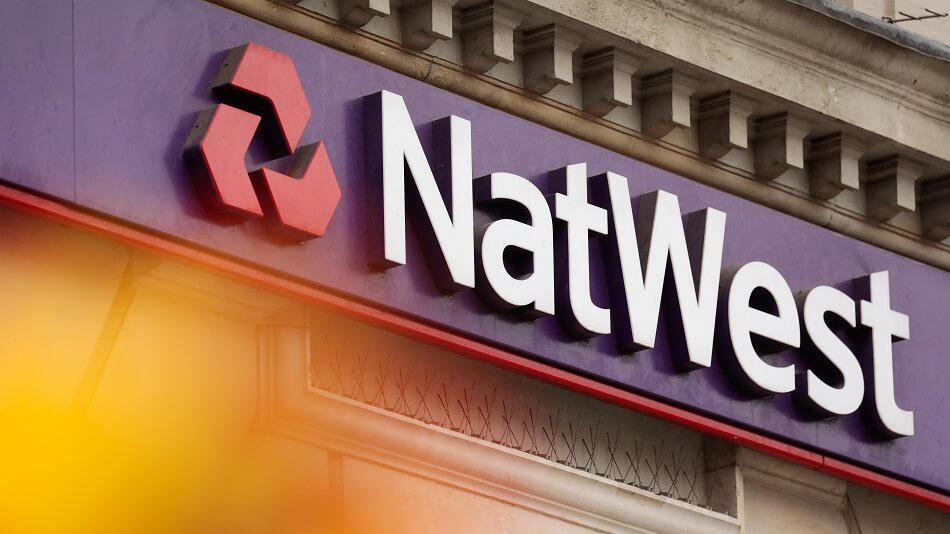A NatWest logo sits on a NatWest Group Plc bank branch in London, U.K., on Monday, July 27, 2020. The Treasury is in talks with the U.K.'s largest banks about a plan to tackle billions of pounds of bad debts expected under the government's Coronavirus loans program for small businesses, the Financial Times reported. Photographer: Jason Alden/Bloomberg via Getty Images